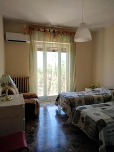 モーラ・ディ・バーリにあるIl Roseto di Molaのベッドルーム1室(ベッド2台、窓付)