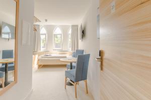 um quarto com uma mesa e cadeiras e uma porta em Hotel Johnsburg em Uelzen