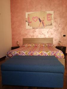 ナポリにあるB&B Smiling Naplesのベッドルームに青いオットマン付きのベッド1台