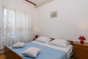 a bedroom with a bed with two pillows on it at Trogir apartment Blaga in Trogir