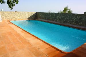 una gran piscina azul con suelo de baldosa en Villa Caramelo, en Castril