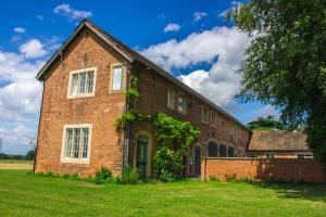 an old brick building on a grass field at Tailor Room 1 in Lincoln