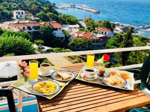 a table with two plates of breakfast food on a balcony at Rooms Olympia in Gialiskari