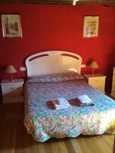 a bedroom with a bed in a red wall at Casa Batit in Viscarret-Guerendiáin