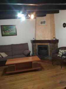 a living room with a couch and a fireplace at Casa Batit in Viscarret-Guerendiáin
