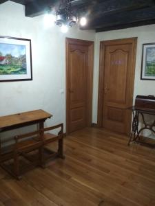 a room with a wooden table and wooden doors at Casa Batit in Viscarret-Guerendiáin
