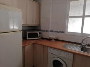 a kitchen with a washing machine and a microwave at APplaya in El Puerto de Santa María