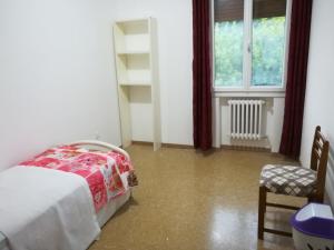 a bedroom with a bed and a chair and a window at Stay Venice Guesthouse in Marghera
