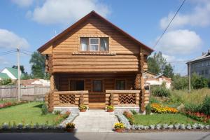 una pequeña casa de madera con un jardín delante de ella en Koshkin Dom, en Myshkin