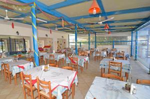 a restaurant with white tables and chairs and blue ceilings at Levante taverna studios in Alikanas