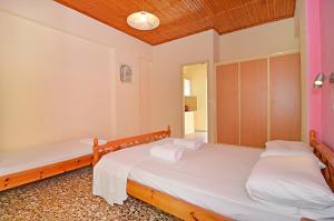 a bedroom with two beds and a mirror at Levante taverna studios in Alikanas