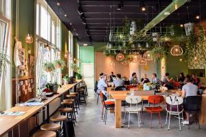 een groep mensen die aan tafel zitten in een restaurant bij Little Duke Hotel in Den Bosch