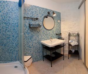La salle de bains est pourvue d'un lavabo et d'une douche. dans l'établissement Bed & Breakfast Vila Baguc, à Split