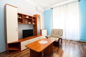 a living room with a tv and a table and a chair at Apartments Kinkela in Opatija