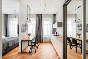 a room with a bed, table, chairs and a window at Piano Apartments in Kaunas