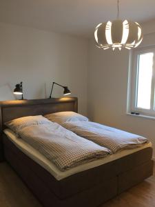 a bedroom with a bed and a light fixture at Weststrandperle in Norderney