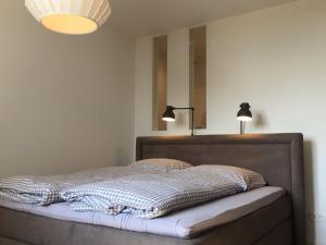 łóżko z dwoma lampami na górze w obiekcie Weststrandperle w mieście Norderney