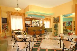 a room with tables and chairs and a bar at Hotel La Conchiglia in Marciana Marina
