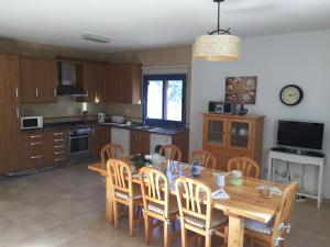 cocina con mesa de comedor de madera y sillas en Es Lliri Blanc, en Cala Saona