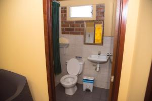 a small bathroom with a toilet and a sink at Tropiclub Playa El Cuco in El Cuco +31 photos