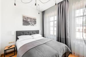 Un dormitorio con una cama grande y dos ventanas. en Piano Apartments, en Kaunas 119 fotos más