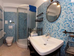 La salle de bains est pourvue de carrelage bleu, d'un lavabo et d'une douche. dans l'établissement Bed & Breakfast Vila Baguc, à Split