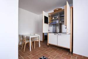 een keuken en eetkamer met een tafel en stoelen bij Pé na Areia - Guest House in Vila Real de Santo António