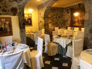 een eetkamer met witte tafels en witte stoelen bij Sas Benas in Santu Lussurgiu