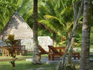 a park with two benches and a thatch hut at Java Lagoon in Pangandaran