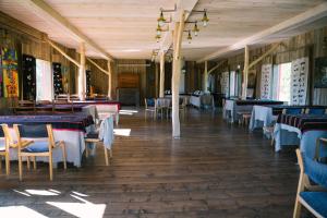 a dining room with tables and chairs in a restaurant at Aavikunurga Guesthouse in Kõiguste