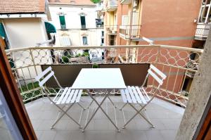 een witte tafel en stoelen op een balkon bij Iris Amalfi Dreams in Minori