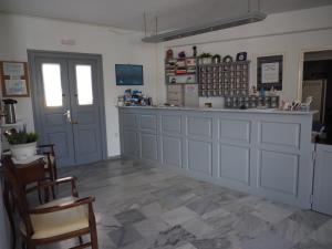 a bar in a room with a counter and chairs at Arkas Inn in Logaras