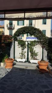 un arco con plantas en macetas frente a un edificio en Nel Giardino di Carla, en Rapallo