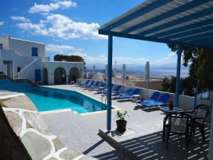 a swimming pool with chairs and a view of the ocean at Arkas Inn in Logaras