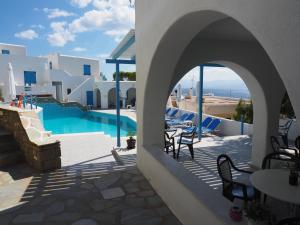 un patio con piscina, mesas y sillas en Arkas Inn, en Logaras