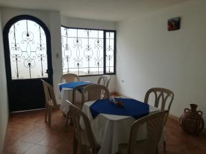 a dining room with two tables and a window at Hotel el mesón Tinjacá in Tinjacá