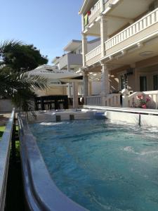 a swimming pool in front of a house at Guesthouse Villa Jurišić in Novalja