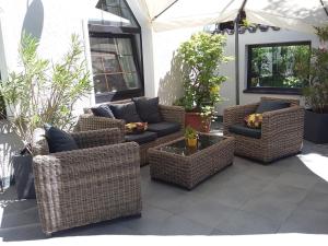 a group of wicker chairs and couches on a patio at Hotel Restaurant Molitor in Bad Homburg vor der Höhe