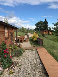 a backyard with a picnic table and a bench at Jaunbirzes in Vecsaule