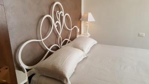 a bed with a white headboard with a lamp on it at Residenza Via Rocca Tre in Lazise