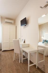 Dieses weiße Zimmer verfügt über einen Schreibtisch und ein Bett. in der Unterkunft Hotel Soraya - Spiaggia Sawasdee in Riccione