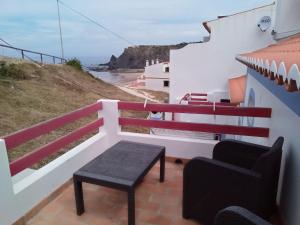 a balcony with a bench and a view of the ocean at Casa Pedra da Foz in Odeceixe