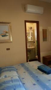 Schlafzimmer mit einem Bett mit blauer Decke in der Unterkunft Monolocale Seaside in Reggio di Calabria