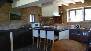a kitchen with a counter and some chairs in it at Finca El Zurrador in Fuenteheridos