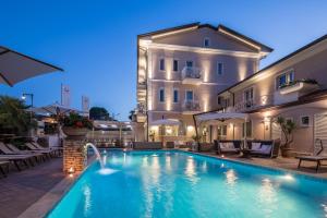 a hotel with a swimming pool in front of a building at Hotel Luna in Marina di Massa