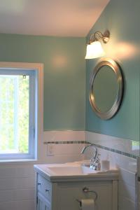 a bathroom with a sink and a mirror at La Maison Jaune D'Eastman in Eastman