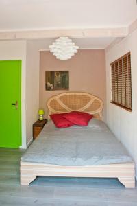 um quarto com uma cama grande e uma almofada vermelha em Le Cabanon de Monte-Carlo avec Jardin Privé em Monte Carlo