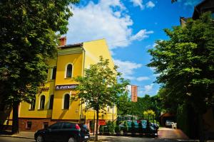 a yellow building with a car parked in front of it at BL Luxus Apartman in Szeged