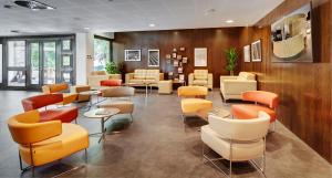 une salle d'attente avec des chaises et des tables dans un hôpital dans l'établissement Sercotel Gran Hotel Zurbarán, à Badajoz