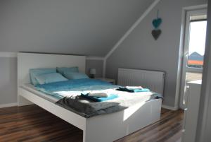 een slaapkamer met een bed met blauwe kussens erop bij Apartament Nad Jeziorem Kaszuby in Gołubie